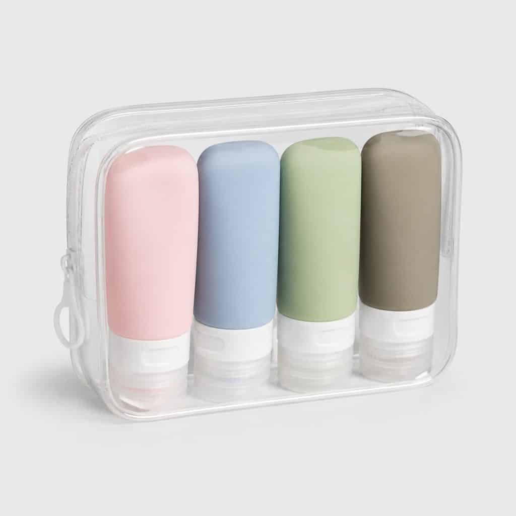 Quatre flacons de voyage en silicone de couleurs différentes avec pochette transparente