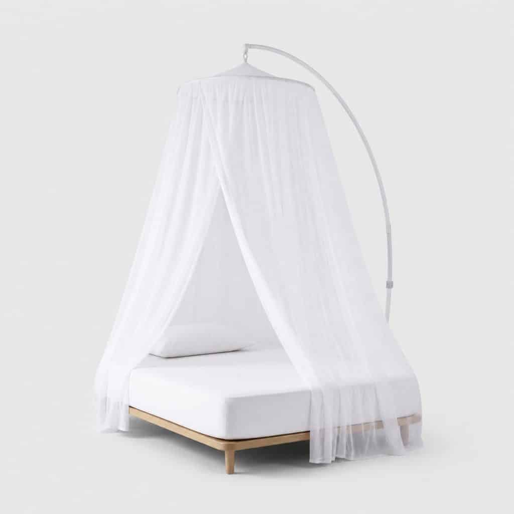 Voile de moustiquaire blanc suspendu au-dessus d'un lit